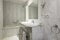 bathroom with marble sink and matching marble covered floors