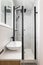 Bathroom with modern designer renovation and fittings. Vanity sink with black faucet. Walls of white granite tiles and