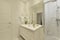 Bathroom with one-piece white porcelain sink, large frameless wall mirror