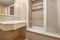 Bathroom with porcelain sink suspended over marble countertop, mosaic tile