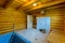 A bathroom room for a contrast shower with a bucket and a wooden sun lounger