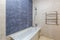 Bathroom with shower, bathtub and light tiles