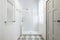 Bathroom with shower cabin with glass partition, white towel radiator, small white tiled