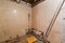 Bathroom with shower with tiled walls , construction trash are in apartment that is under construction, remodeli