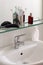 Bathroom sink with body care equipment on a glass shelf with copy space for your text