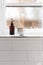 Bathroom soap dispenser and pot on window ledge with negative sp