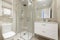 Bathroom with square shower cabin with glass partition, white porcelain