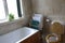 Bathroom with towel rail and white bath and toilet with wooden seat