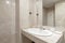 bathroom with white porcelain sink on marble countertop, cream