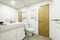 Bathroom with white towel radiator, wall-to-wall mirror, pine wood door