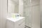 Bathroom with white walls and frameless wall mirror, white porcelain
