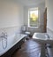 Bathroom with white walls and large black bathtub