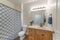 Bathroom with wooden vanity sink with flower vase and mirror