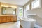 Bathroon interior with vanity cabinet, two sinks and white bath tub.