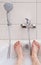 A bathtub in a bathroom filled with warm water and foam, only the feet of a person are shown