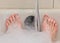 A bathtub in a bathroom filled with warm water and foam, only the feet of a person are shown