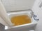 bathtub full of yellow water due to rust or impurities