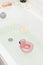 Bathtub with Plumerria Flowers and Inflatable Flamingo Toy Ring with Drink Bamboo Face Brush Home SPA Concept Relax Vertical