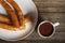 Batons with chocolate on wooden background. Typical Spanish appetizer like fried dough