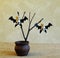 Bats from corks and black cardboard on an old dry branch in a ceramic vase on a homespun jute fabric against light wall. Concept