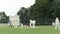 Batsman plays a drive shot in a cricket game