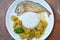 Batter fried mackerel coating egg yolk and boiled chicken bamboo shoot curry with rice on plate