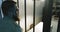 A battered man with a beard stands in the prison cell.