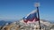 A battered Russian flag is flying at the top of the mountain. Against the background of Mount Fisht. National Nature Reserve