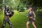 Battle of a fantasy warrior girl and a medieval knight in full set armor in the park