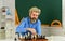 Battle of minds. bearded man training for chess competition. chess figures on wooden board. Focused school teacher