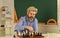 battle of minds. bearded man training for chess competition. chess figures on wooden board. Focused school teacher