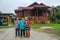 Batu Pahat, Malaysia - May 3rd, 2022 :  Happy Malay family in traditional clothing and traditional Malay house during Hari Raya.
