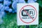 BATUMI, GEORGIA - 10 JULY 2017: Plate Free Wi Fi zone is over. Blue flowers on the background. Close-up