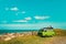 Batumi, Georgia - September 14, 2018: Young male lying on top of the green old timer classic camper van parked near the sea shore