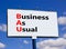 BAU business as usual symbol. Concept words BAU business as usual on white billboard against blue sky and clouds. Beautiful