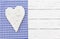 Bavarian background with white wooden heart on blue checked fabric border and white wood