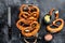 Bavarian baked Salted pretzels in a wooden tray. Black background. Top view
