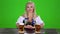 Bavarian girl takes on the table two glasses of beer nd shows thumbs. Green screen. Slow motion