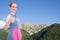 Bavarian girl with thumb up and blue sky as background