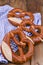 Bavarian pretzel decorated with a blue and white cloth on a rustic wooden board - Munich Oktoberfest. Vertical format