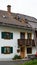 Bavarian Roofer works to repair a red tiled roof on his typical Bavarian home