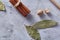 Bay leaf, nutmeg and spices on white textured background, top view, close-up, selective focus.