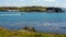 Bay with a motorboat sailing with the ruins of Cromwellâ€™s Barracks in the background on Inishbofin Island