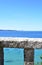 Bay with stone handrail, trees and sailing boats. Rias Baixas, Spain.