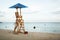 Baywatch chair in a beautiful beach empty at summer sunset.