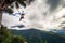 BaÃ±os - August 19, 2018: Tourists riding the famous Casa de Arbol End of the World swing in BaÃ±os, Ecuador