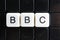 BBC text word crossword. Alphabet letter blocks game texture background. White alphabetical letters on black background