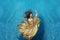Bbeautiful young woman in gold dress, evening dress floating weightlessly elegant floating in the water in the pool