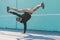 BBOY dancing breakdance against a blue wall