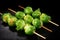 bbq brussels sprouts on a wooden skewer on a black background